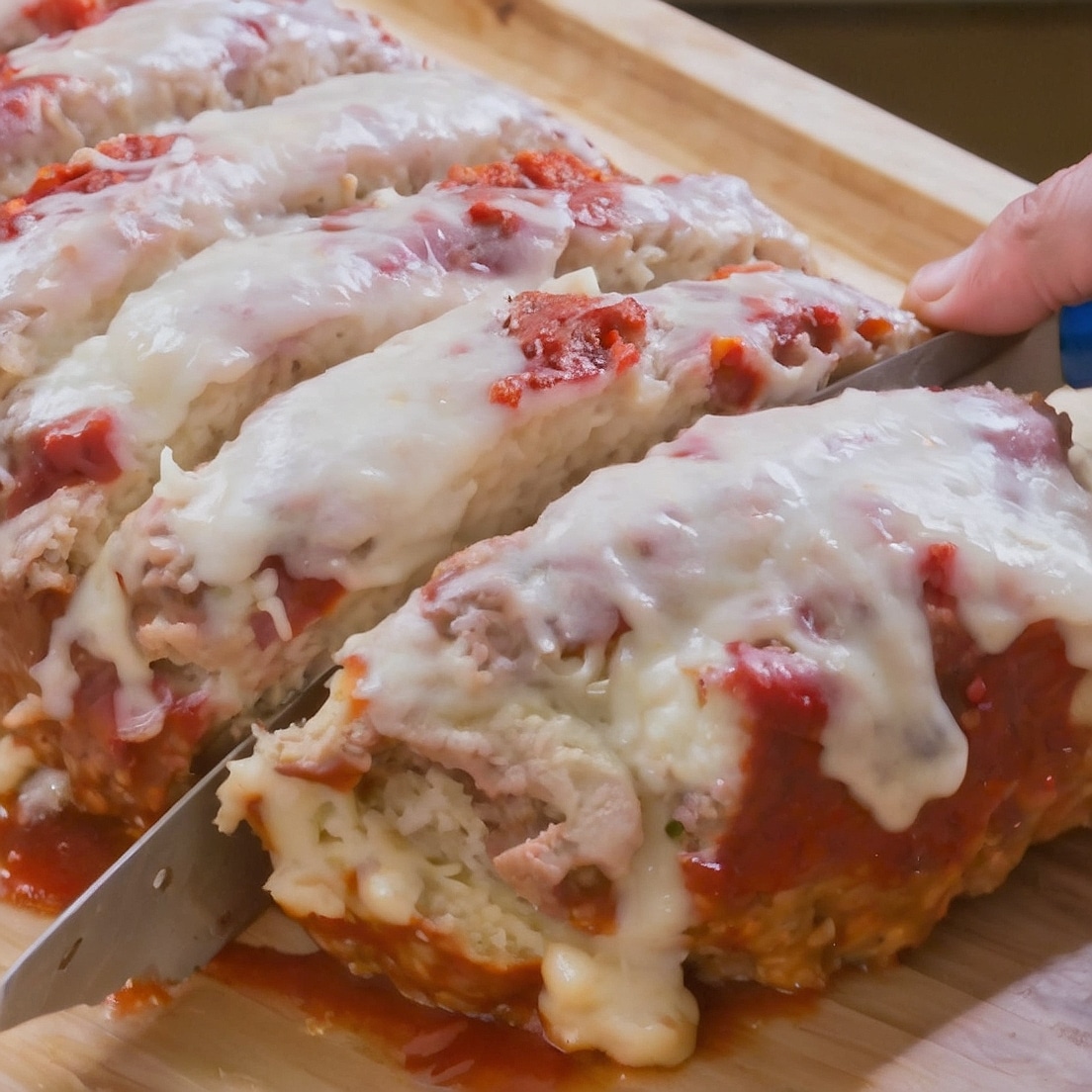 Italian meatloaf recipe topped with melted mozzarella cheese and marinara sauce.